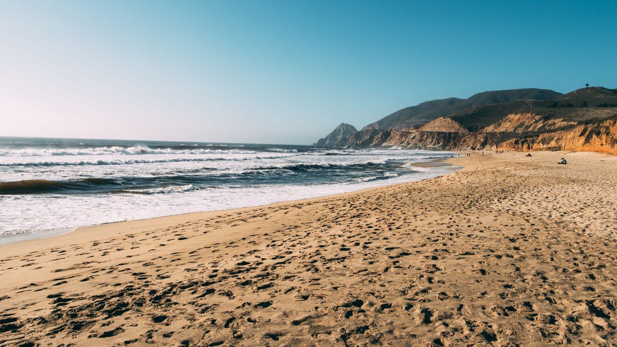 Deux jeunes femmes emportées par une vague sur une plage californienne